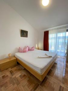 a bedroom with a large bed with pink pillows at Villa Janja in Šilo