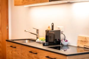 ツェルマットにあるStudio Nova, Zermattのシンクと電子レンジ付きのキッチンカウンター +7枚の写真