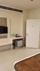 a kitchen with a white refrigerator and a table at Hotel Le castle in Jāmb