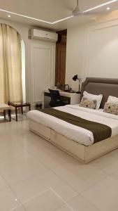 a bedroom with a large bed and a desk at Hotel Le castle in Jāmb