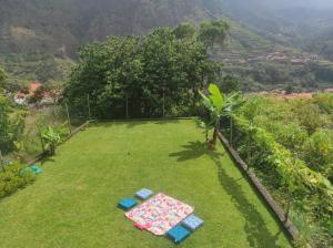 a garden with a blanket on the grass at CASA GIRASSOL " uma Janela para o Nascer do Sol " in São Vicente
