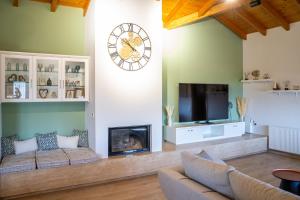 a living room with a couch and a clock on the wall at Kallidimi's House in Monemvasia