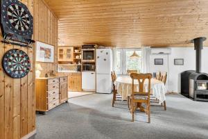 a kitchen with a table and a dart board on the wall at 560-Thisted-Klitrosevej-60 in Thisted
