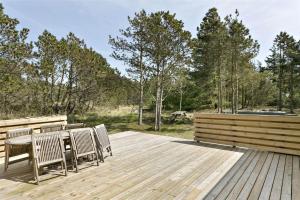 a wooden deck with a table and chairs on it at 560-Thisted-Klitrosevej-60 in Thisted