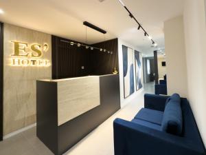 地拉那ES Hotel的酒店大堂配有蓝色沙发和接待台