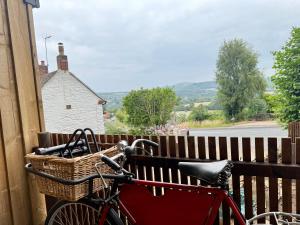 a bike with a basket parked next to a fence at Retreat In The Hills, 1 Bedroom - Malvern in Mathon
