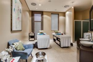 a bathroom with two chairs and a sink and a mirror at Radisson Blu Hotel & Convention Centre Kigali in Kigali