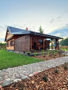 a log cabin with a stone path in front of it at Chatka Oli in Zubacze
