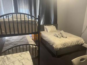 Giường trong phòng chung tại Woodville Lodge Leeds - A Cosy Guest House with Self Service Residents Kitchen