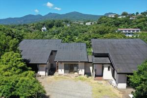 eine Luftansicht eines Hauses mit zwei Dächern in der Unterkunft ファミーユグループ城ケ崎店 空音sorane in Ito