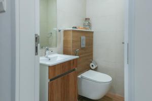 a small bathroom with a toilet and a sink at Oasis 2 Masdar City in Abu Dhabi