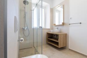 a bathroom with a glass shower and a sink at Apartments Cassia in Mali Lošinj