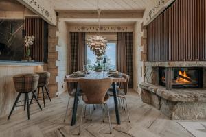 a dining room with a table and a fireplace at Tatra Bjerge View in Zakopane