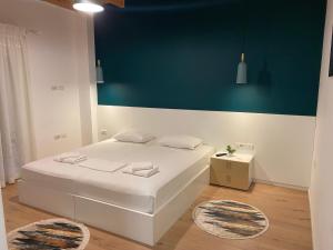 a bedroom with a white bed and a blue wall at Villa Perikli in Delvinë +6 photos