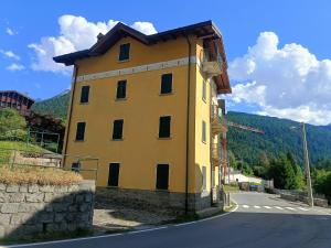a yellow building on the side of a road at Natali Home by Holiday World in Ponte di Legno