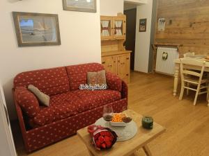 a living room with a red couch and a table at Natali Home by Holiday World in Ponte di Legno +10 photos