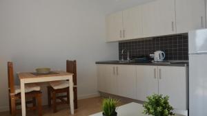 a kitchen with white cabinets and a small table at Apt. El Molino 3A in Valle Gran Rey