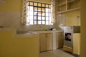 a kitchen with a sink and a refrigerator and a window at Mona Homes one-bedroom Apartment in Voi