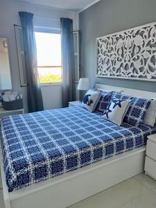 a bedroom with a bed with a blue and white blanket at Mondello Sunshine Apartment in Mondello