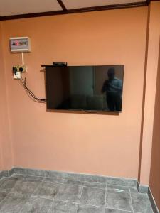 a flat screen tv on a wall with a man on it at RUU Holiday Home in Nuwara Eliya