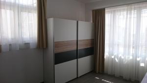 a bedroom with a white cabinet and windows at Beautiful Apartment Jukic in Podstrana