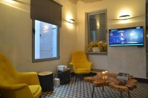 アテネにあるContemporary Acropolis Houseのリビングルーム(黄色い椅子、テーブル、テレビ付)