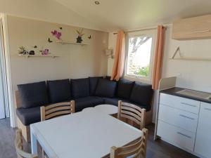 a living room with a couch and a table at MOBILHOME Margueritte in Lattes +4 photos