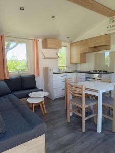 a kitchen and living room with a couch and a table at MOBILHOME Margueritte in Lattes
