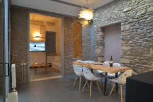 uma sala de jantar com uma parede de pedra e uma mesa e cadeiras em Contemporary Acropolis House em Atenas