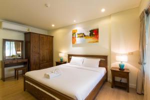 a bedroom with a large white bed with two lamps at Mykonos Condo in Hua Hin +17 photos