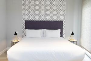 une chambre avec un grand lit blanc avec deux lampes dans l'établissement Be Mate Blasco de Garay, à Madrid