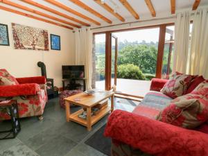 a living room with two couches and a table at Dan Castell Cottage in Llandeilo