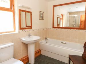 a bathroom with a sink and a tub and a toilet at Dan Castell Cottage in Llandeilo +31 photos