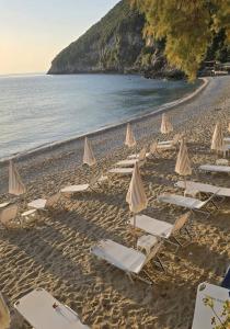a group of chairs and umbrellas on a beach at Sea La Vie in Keramídhion