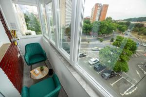 a room with two chairs and a table and a window at Sunset Studio Valcea in Râmnicu Vâlcea