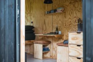 a room with a wooden wall with a table and shelves at Adhara in Tarporley