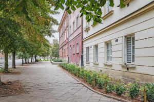 an empty street next to a building with plants at Rynek Nowego Miasta 27 by NYX Apart in Skorka