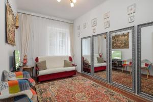 a living room with a mirror and a couch and a tv at Rynek Nowego Miasta 27 by NYX Apart in Skorka