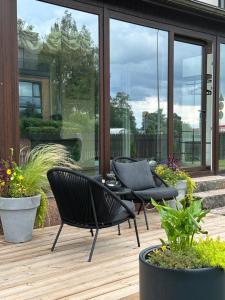a patio with two chairs and a table and some plants at Hugo Apart in Mārupe