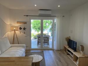 a living room with a couch and a television at COACH HOUSE by SOM Menorca in Son Parc