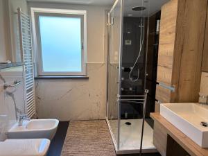 a bathroom with a glass shower and a sink at Alpen Family Hotel Someda in Moena +84 photos