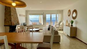Un comedor y sala de estar con vista al mar. en Villa Narcol, en L'Estartit