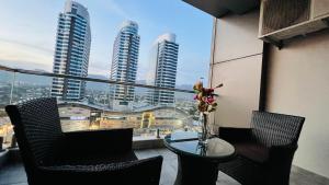 a balcony with a table and chairs and a view of tall buildings at Elysium Executive Hotel Serviced Apartments Facing Centaurus Mall Islamabad in Islamabad