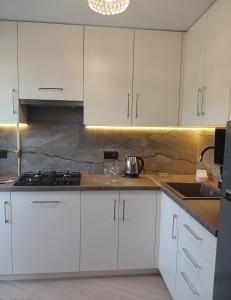 a kitchen with white cabinets and a sink at 2-к Люкс Студія з Окремою Спальнею, Центр, Великий Балкон, Низький Поверх in Mykolaiv