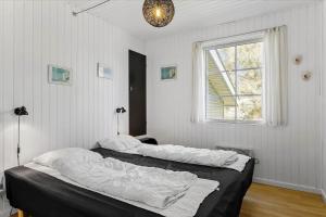 two beds in a white room with a window at 406-Vestervig-Bekkasinvej-6 in Vestervig