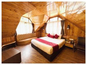 大吉岭Zambala Retreat & Spa Darjeeling的一间木屋里有一张床的卧室