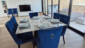 a dining room table with blue chairs and a tableablish at Luxury Beach Penthouse Jacuzzi Lagoon View in Punta Cana