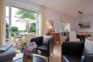 a living room with a couch and a table with flowers at Kairem Ingiwai 22c in Keitum