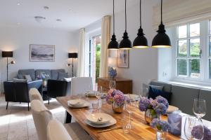a dining room with a table with flowers on it at Kairem Ingiwai 22c in Keitum +12 photos