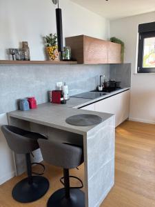 a kitchen with a counter with two bar stools at POLAI Seafront Apartment in Seline